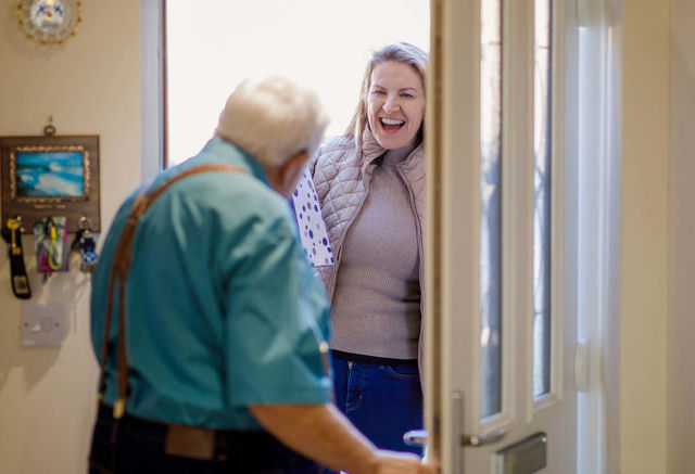 Elderly man meeting carer at the door